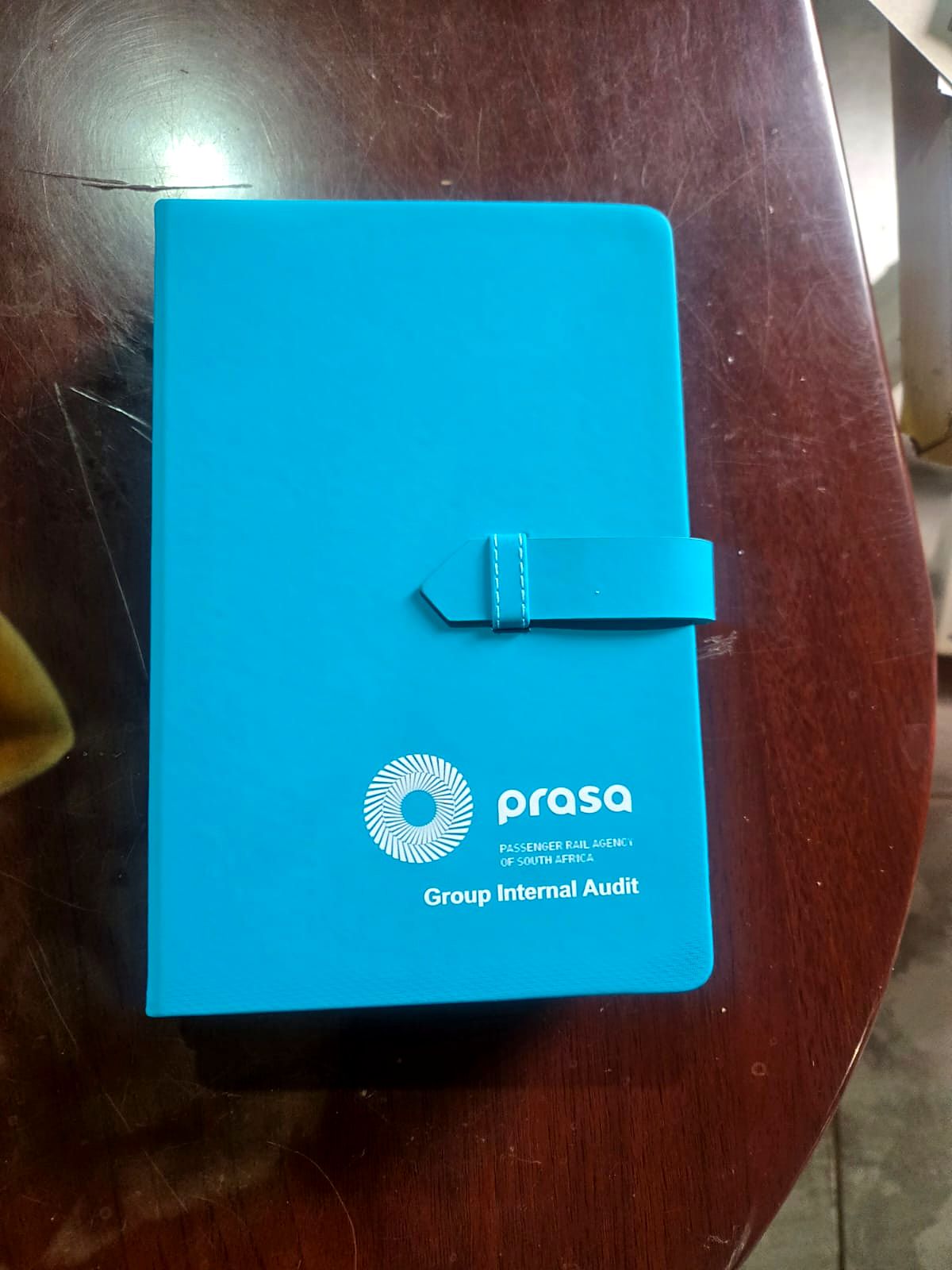 Turquoise PRASA branded notebook with pen loop