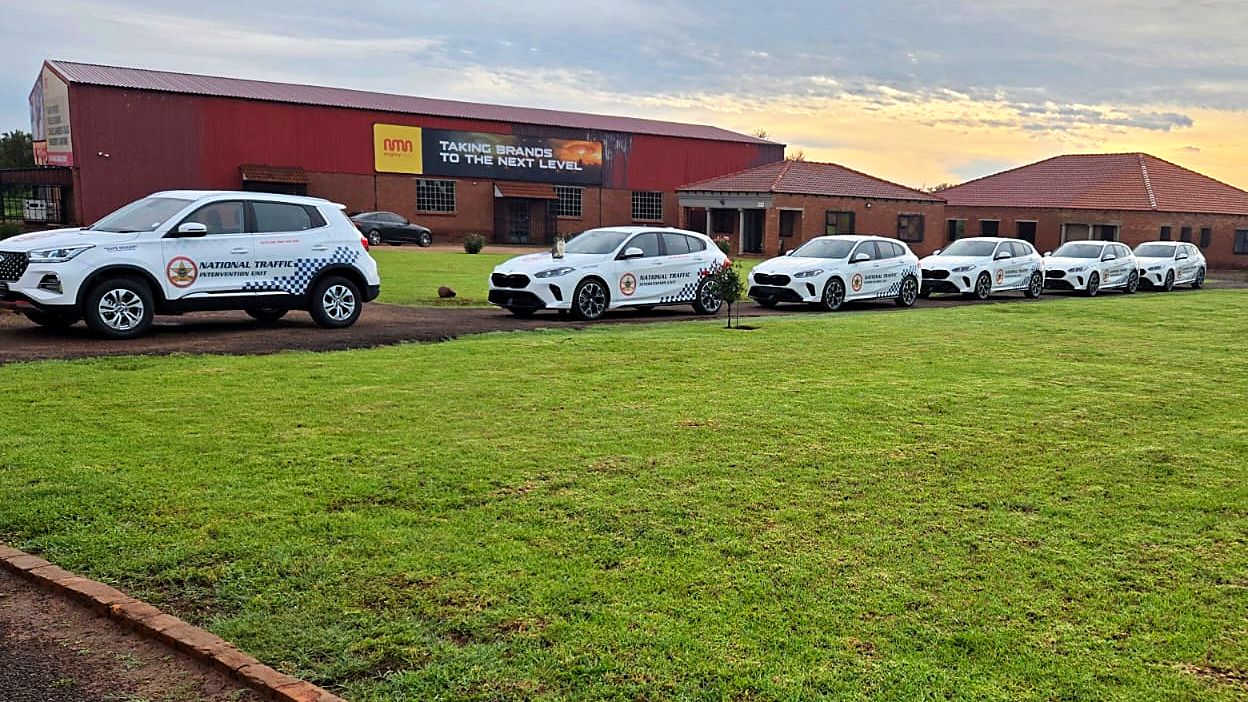 Fleet of cars in National Traffic Intervention Unit livery lined up outside the Mighty Media building