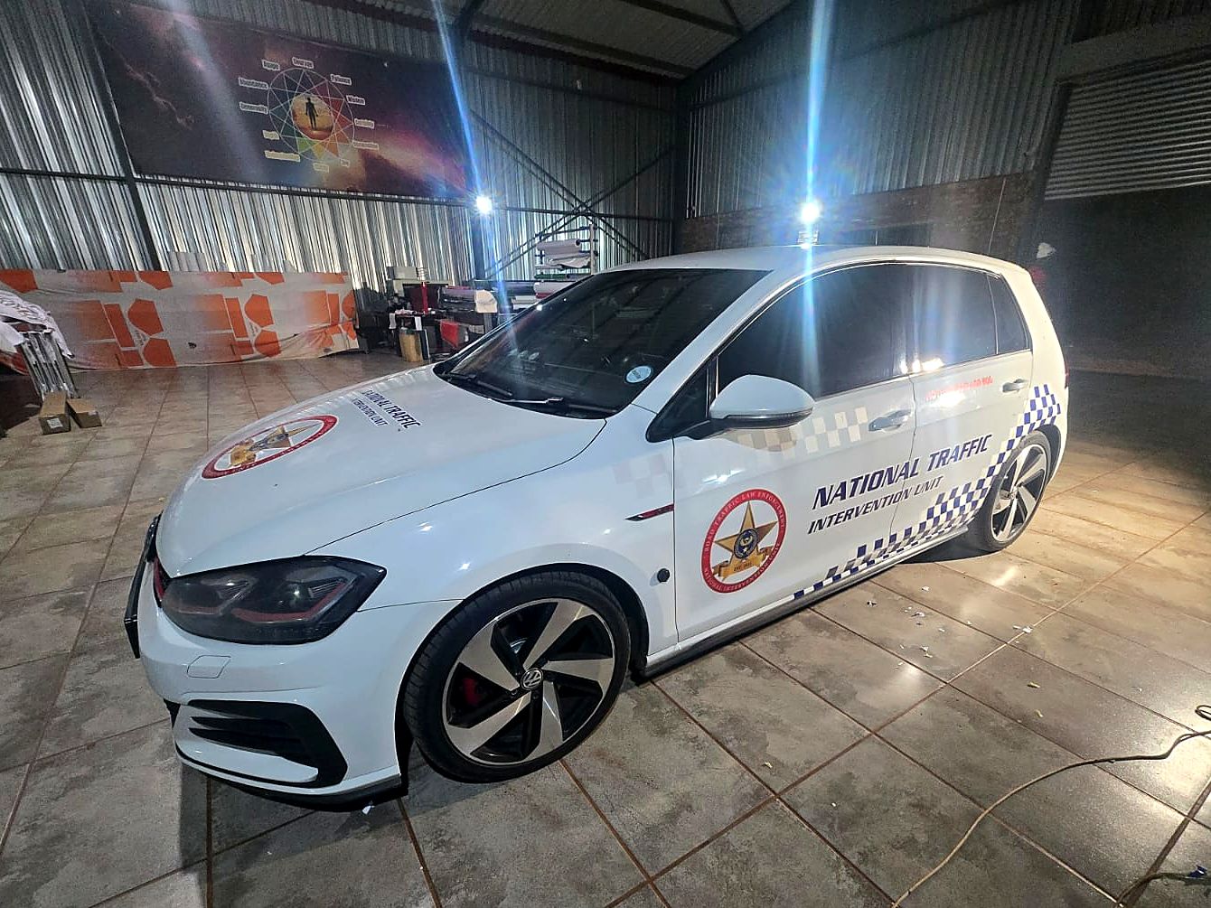 Branded white VW Golf parked inside the Mighty Media workshop